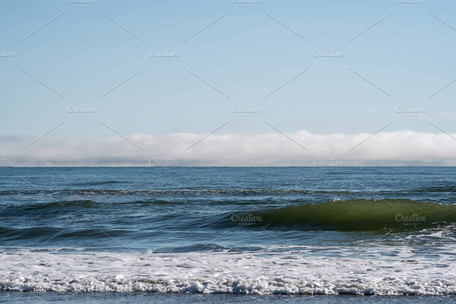 Rolling ocean waves with fog bank, a Photo by Elena Vagengeim