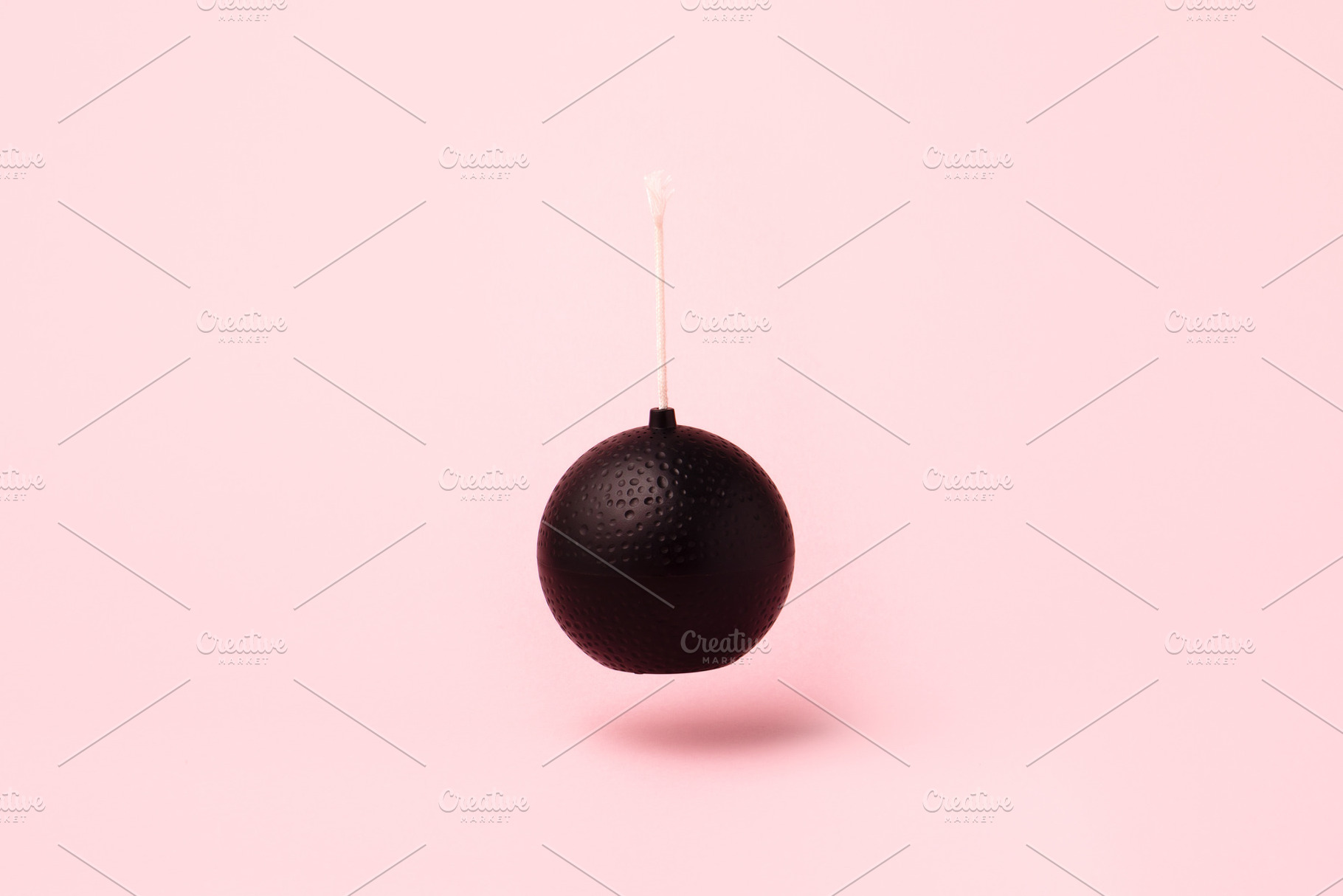Minimalist black bomb with white fuse suspended against pastel p, an Abstract Photo by Ales Munt