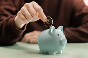 Hand dropping Coin into Piggy bank. Saving money, financial disc, a Photo by salmon.black