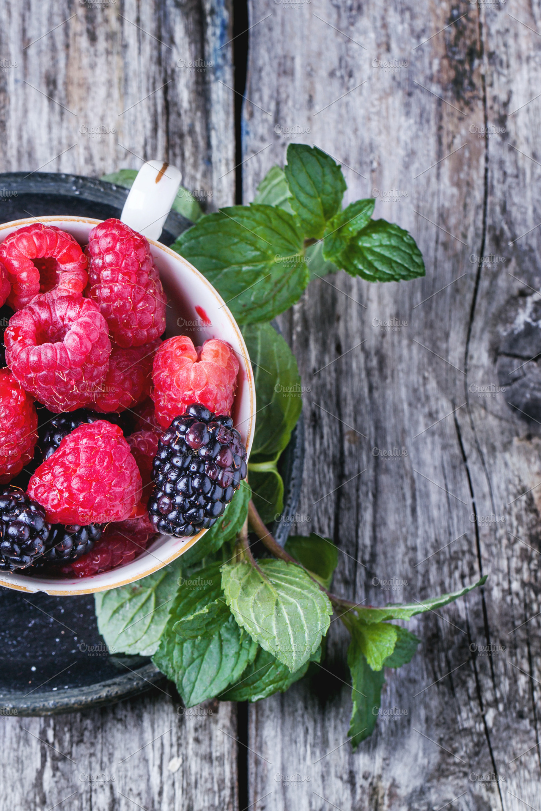 Cup of raspberries and blackberries featuring berries, fruit, and wooden