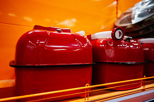 Bright red containers displayed on orange background in a retail store setting, a Photo by AS photostudio
