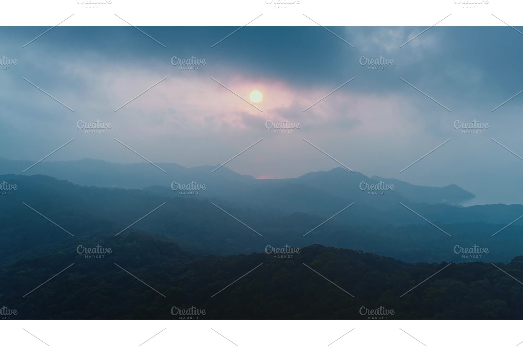 Sun setting behind misty mountains, a Nature Photo by Goinyk