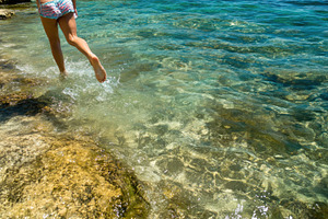 Girl runs barefoot along the shallow, a Photo by Iftikhar Alam