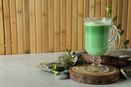 Cup of matcha latte and accessories for making against bamboo ba, a Food & Drink Photo by AtlasStudio PRO
