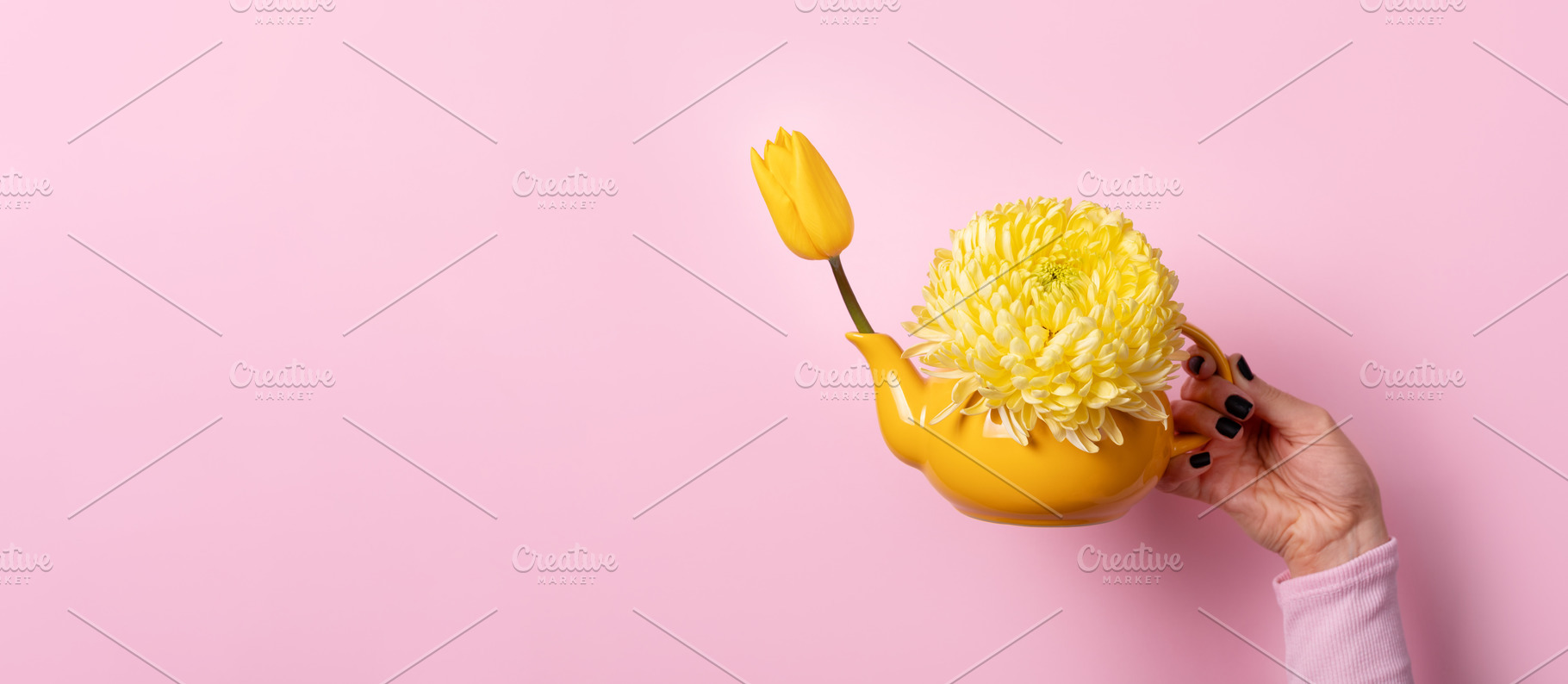 Hand holding yellow teapot with yellow tulip and chrysanthemum o, a Food & Drink Photo by Ales Munt