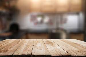 Wooden surface on blurred background of kitchen in apartment.