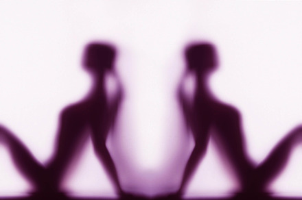 Silhouette of two women in yoga pose