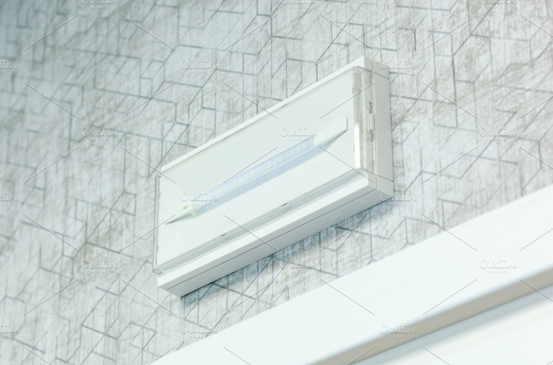 Emergency light on the wall providing safety and guidance during power outages, an Architecture Photo by Antonio Gravante Market