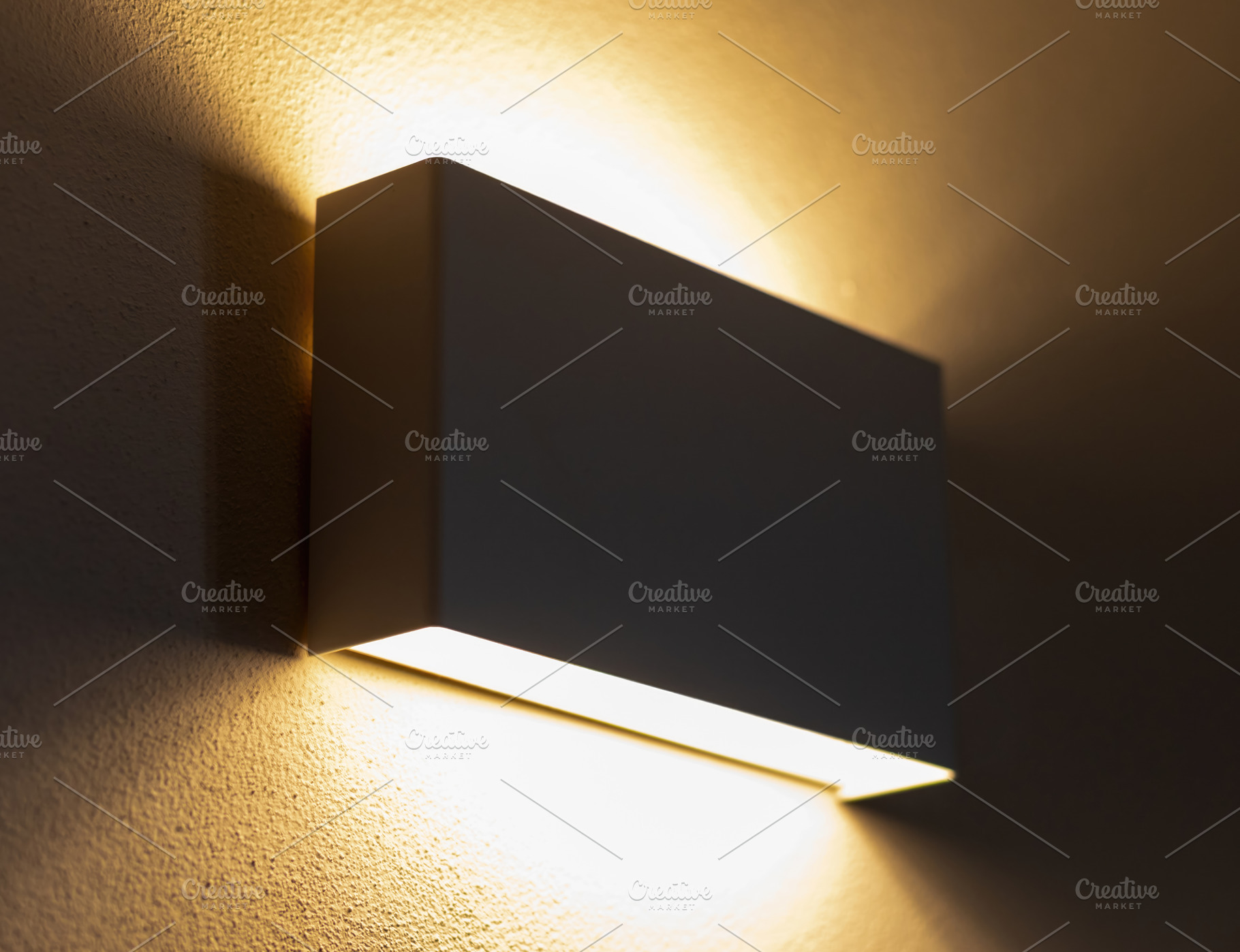 Modern wall lamp illuminating a textured wall, creating a warm ambiance, an Architecture Photo by Antonio Gravante Market