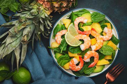 Pineapple salad with shrimps, spinach, avocado and lime on blue, a Food & Drink Photo by 5PH