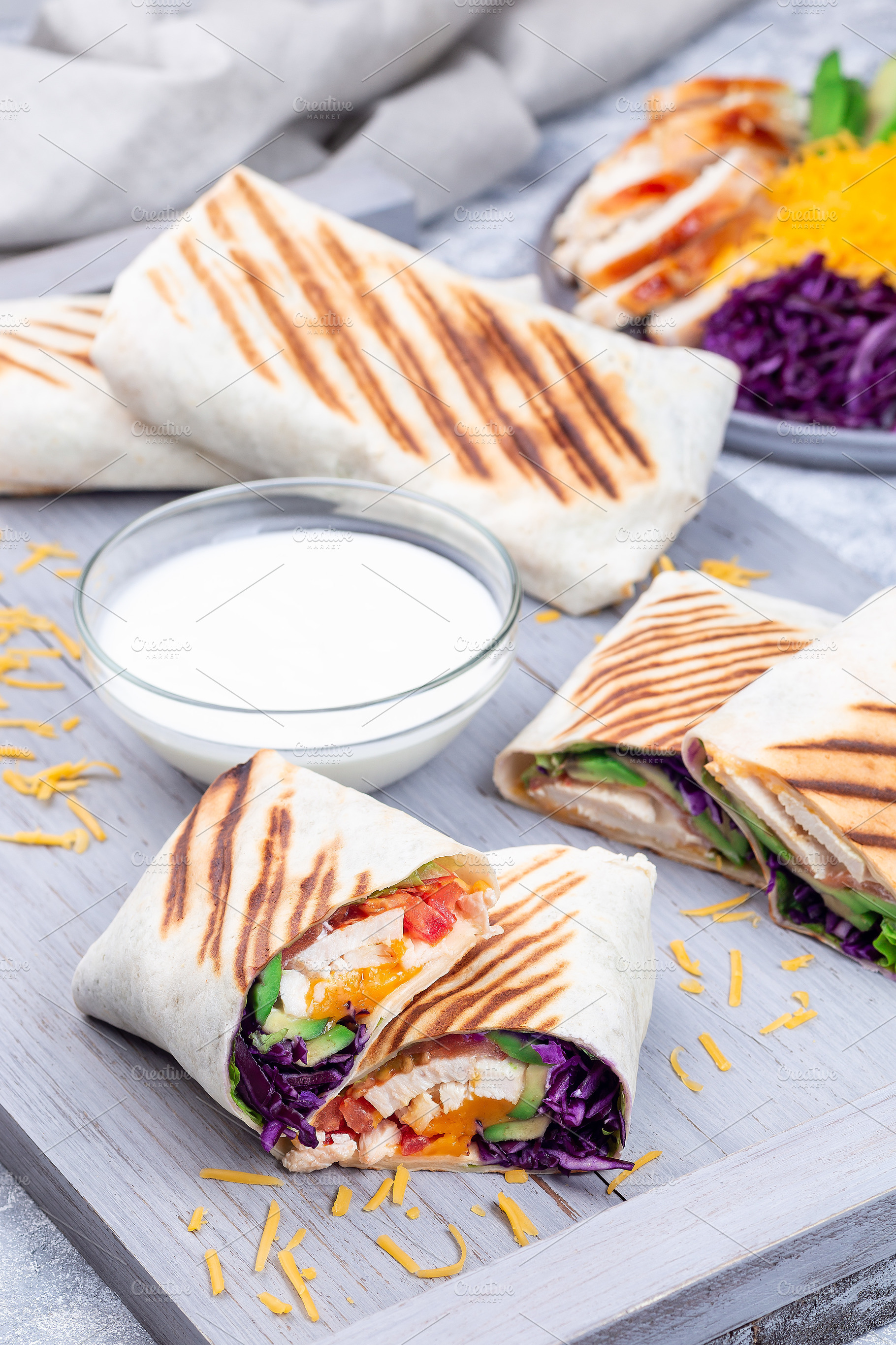 Chicken wraps with red cabbage, avocado, tomato, lettuce, cheddar cheese, on wo, a Food & Drink Photo by iuliia_n