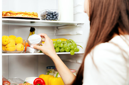 Hand taking, picks up camembert or brie cheese out of open refrigerator, fridge, a Food & Drink Photo by Lenor4ik