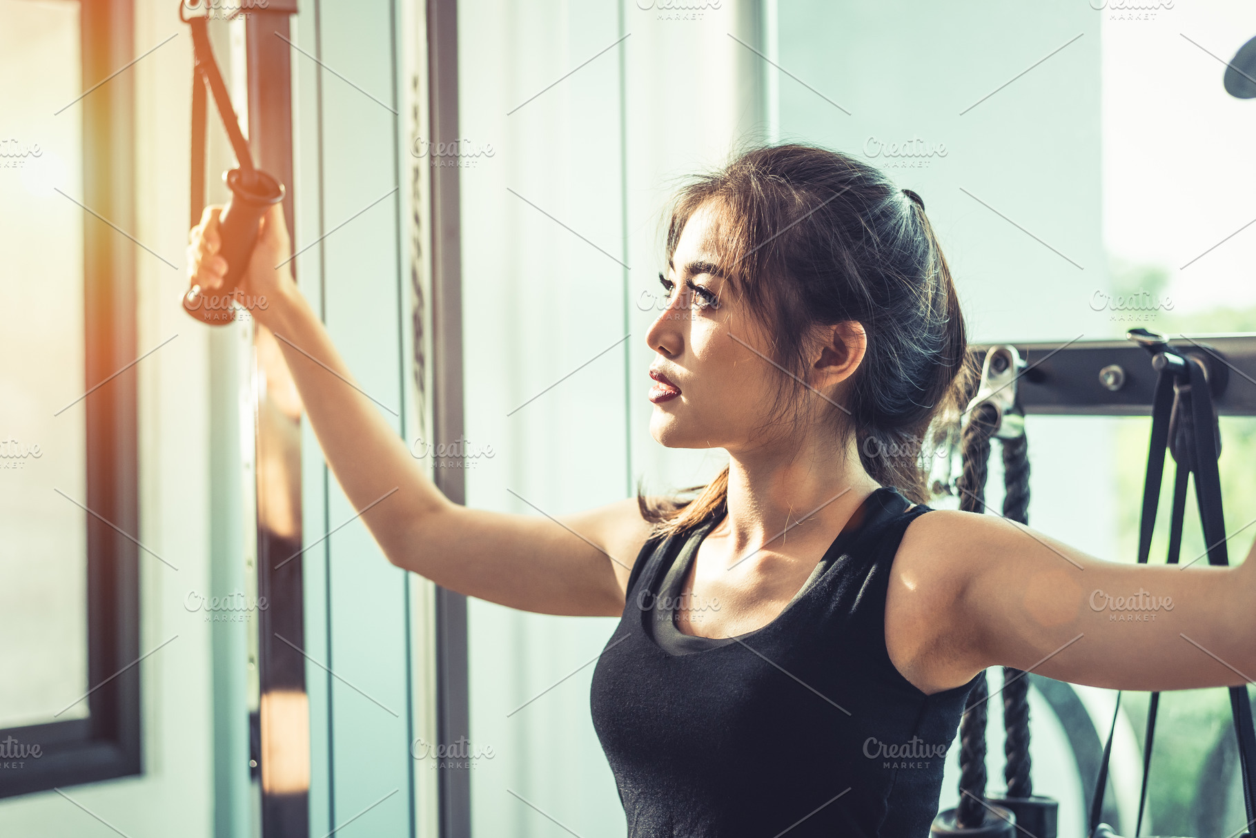 Asian young woman doing elastic rope exercises at cross fitness, a Sports & Recreation Photo by Ministocker