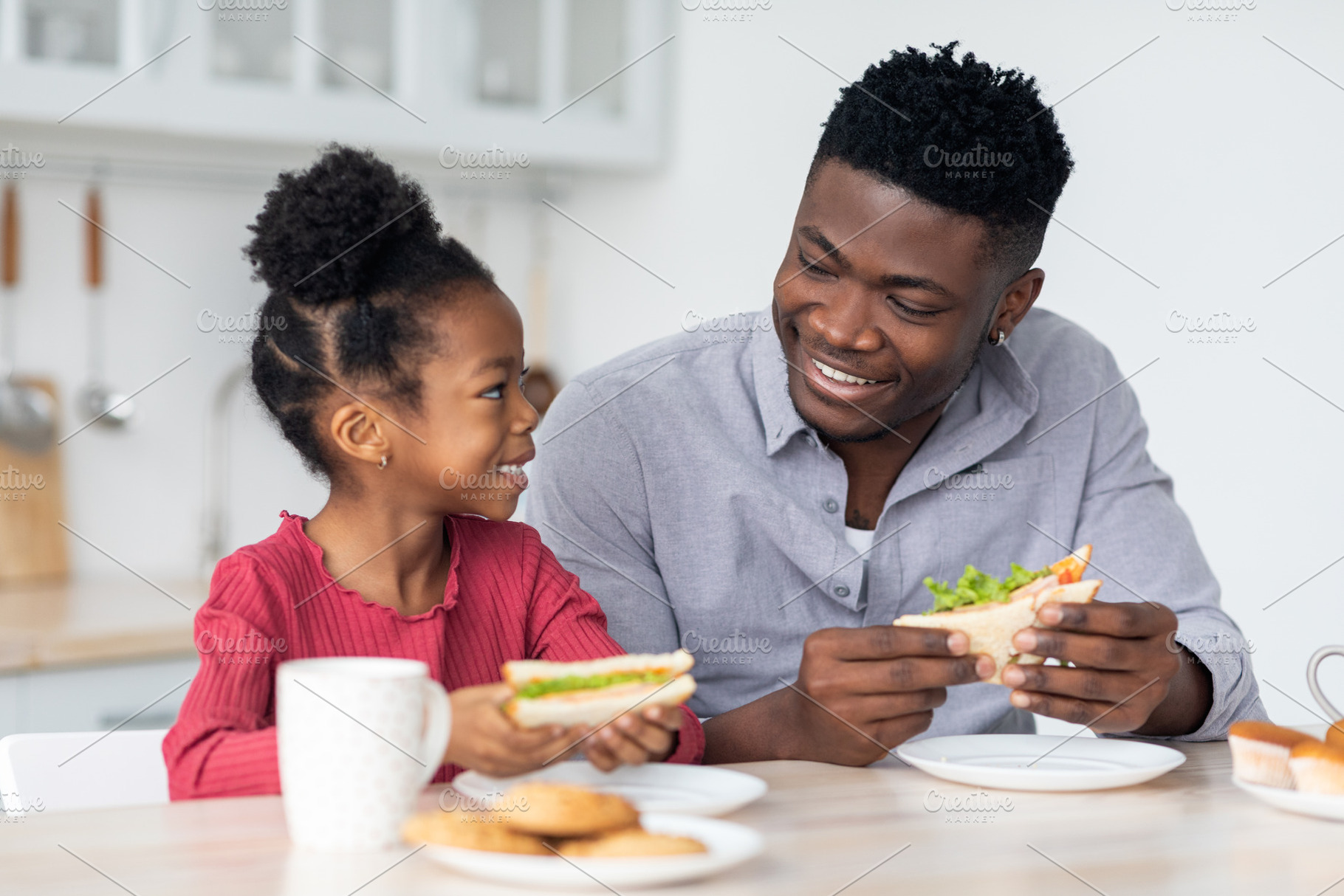 Portrait of loving black family having lunch at home, a Photo by Prostock-Studio