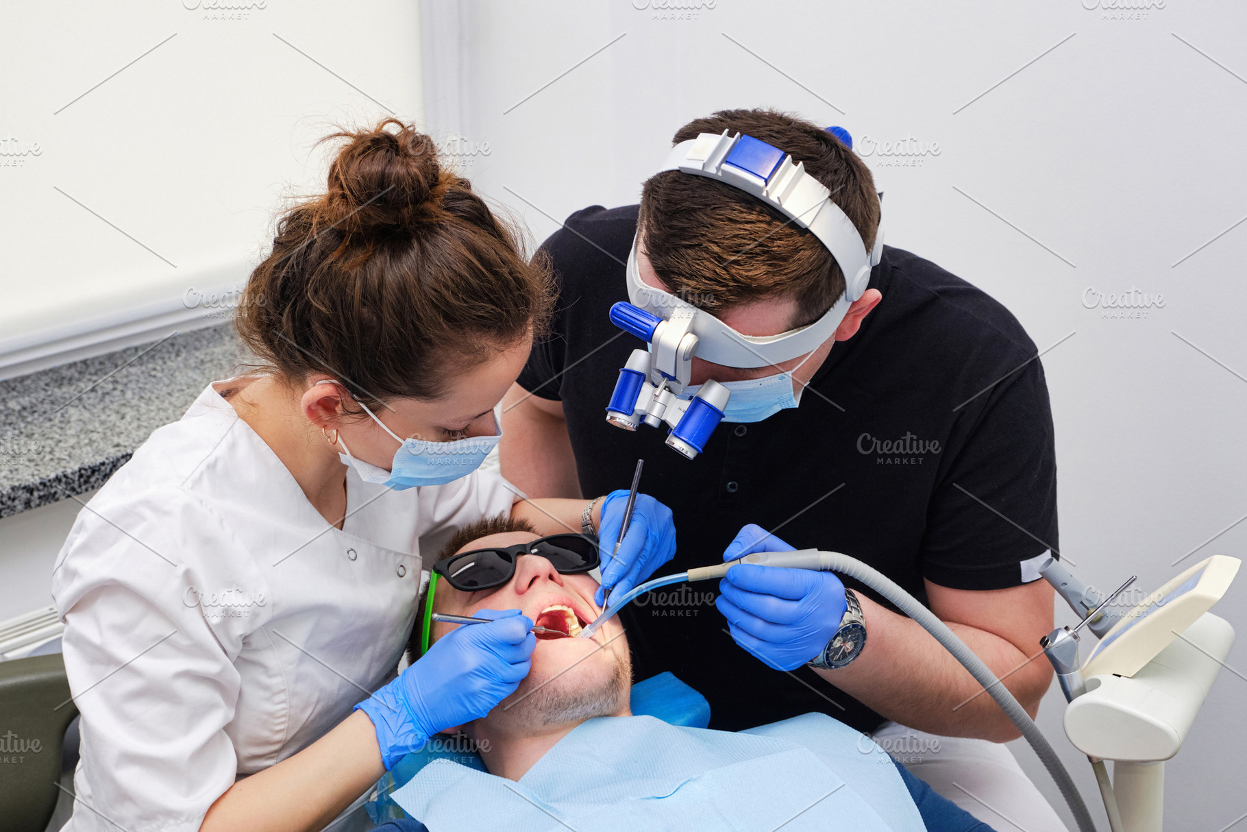 Dentist and his assistant treat a male patient in a dental clinic, a Health & Medical Photo by Rohan Photography
