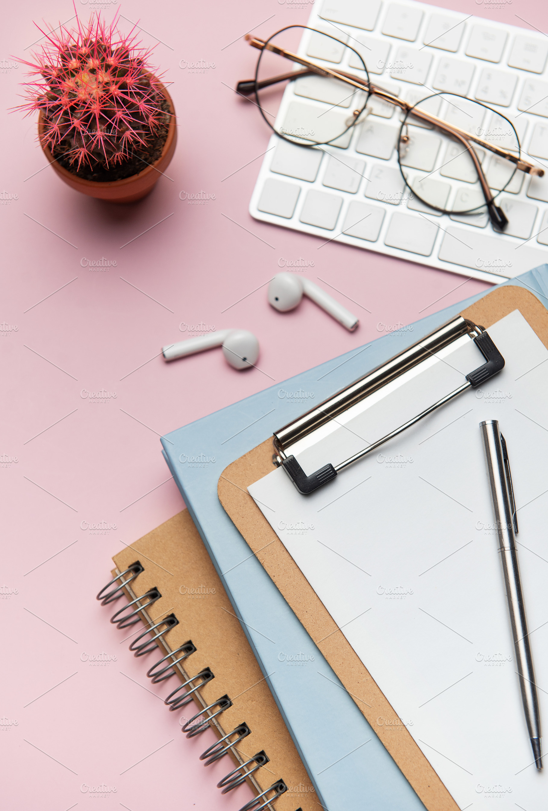 Workspace organizing accessories on pink table with plant and ke, a Business Photo by Olena Rudo