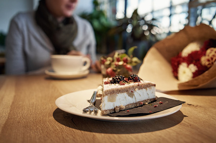 Sweet cake in a cafe with a women having coffee and looking at h, a Food & Drink Photo by Madeleine Steinbach