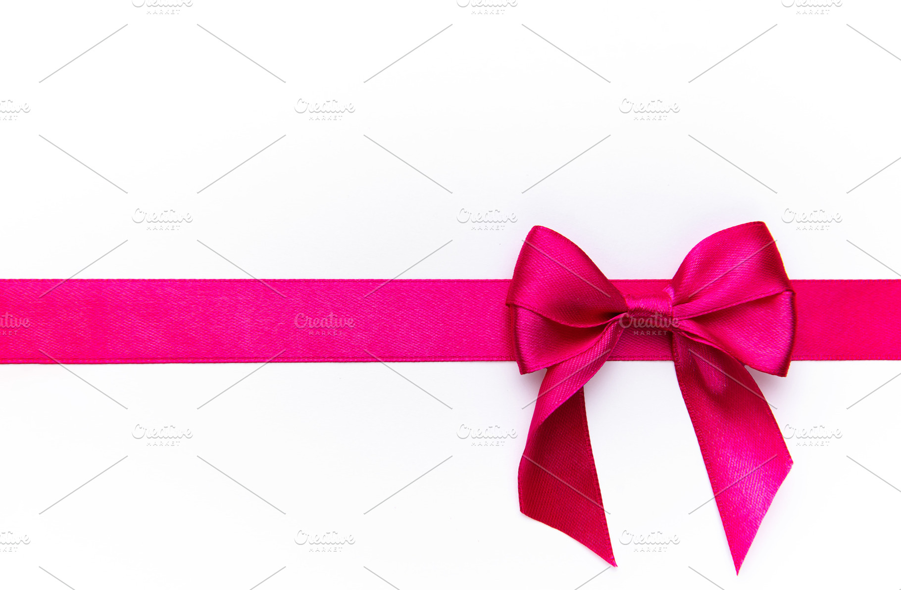Pink satin ribbon forming bow on white background, a Holiday Photo by Olena Rudo