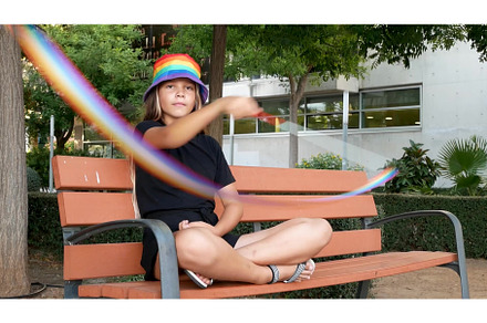 A girl sits on a bench, holding a