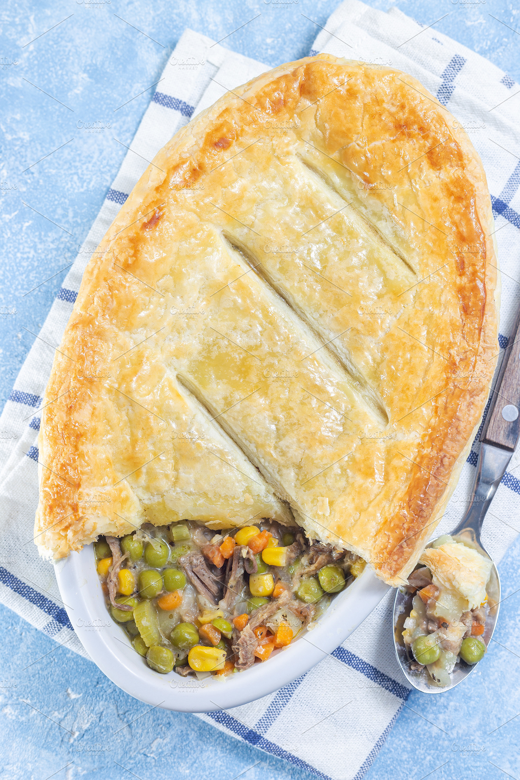 Individual beef pot pie or deep dish pie in baking dish, crust broken open, ver, a Food & Drink Photo by iuliia_n