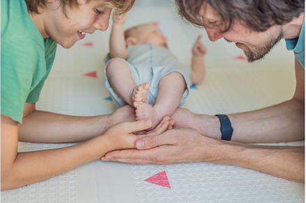 Father, son, and newborn baby lying