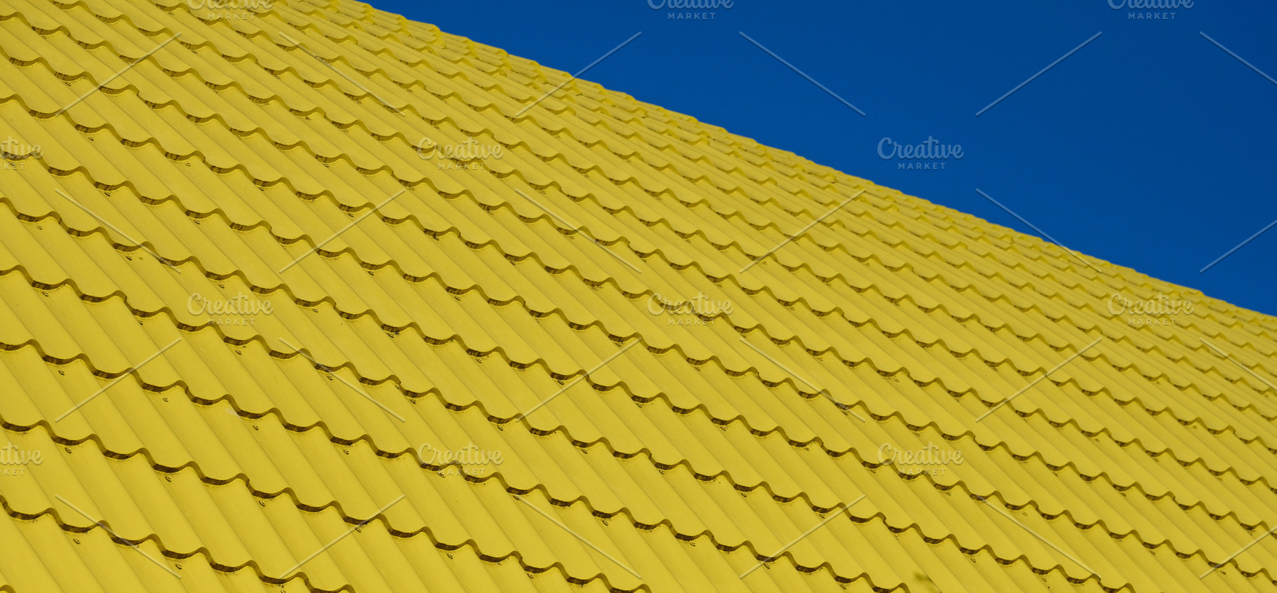 A section of a bright yellow corrugated roof, photographed at an, a Background Photo by ndanko