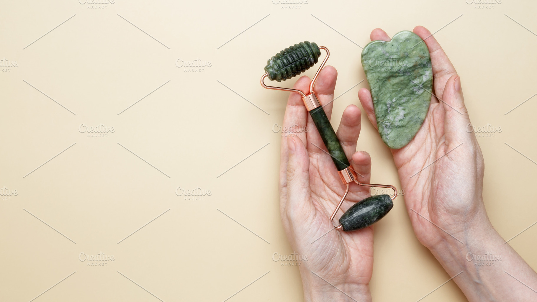 Female hands holding marble face roller and gua sha tools for skincare routine, a Photo by matucha