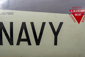 Vintage aircraft fuselage with navy markings and ejection seat w, an Abstract Photo by GoodGoods