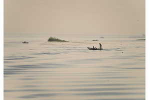 Two men in small wooden fishing boat, a Nature Photo by Backyard Stock