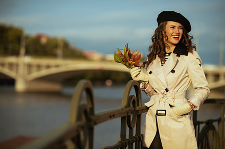 happy elegant woman in beige trench coat and black beret, a Person Photo by Alliance Images