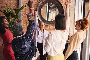 Multi ethnic mixed age range businesswomen cheering in support of International