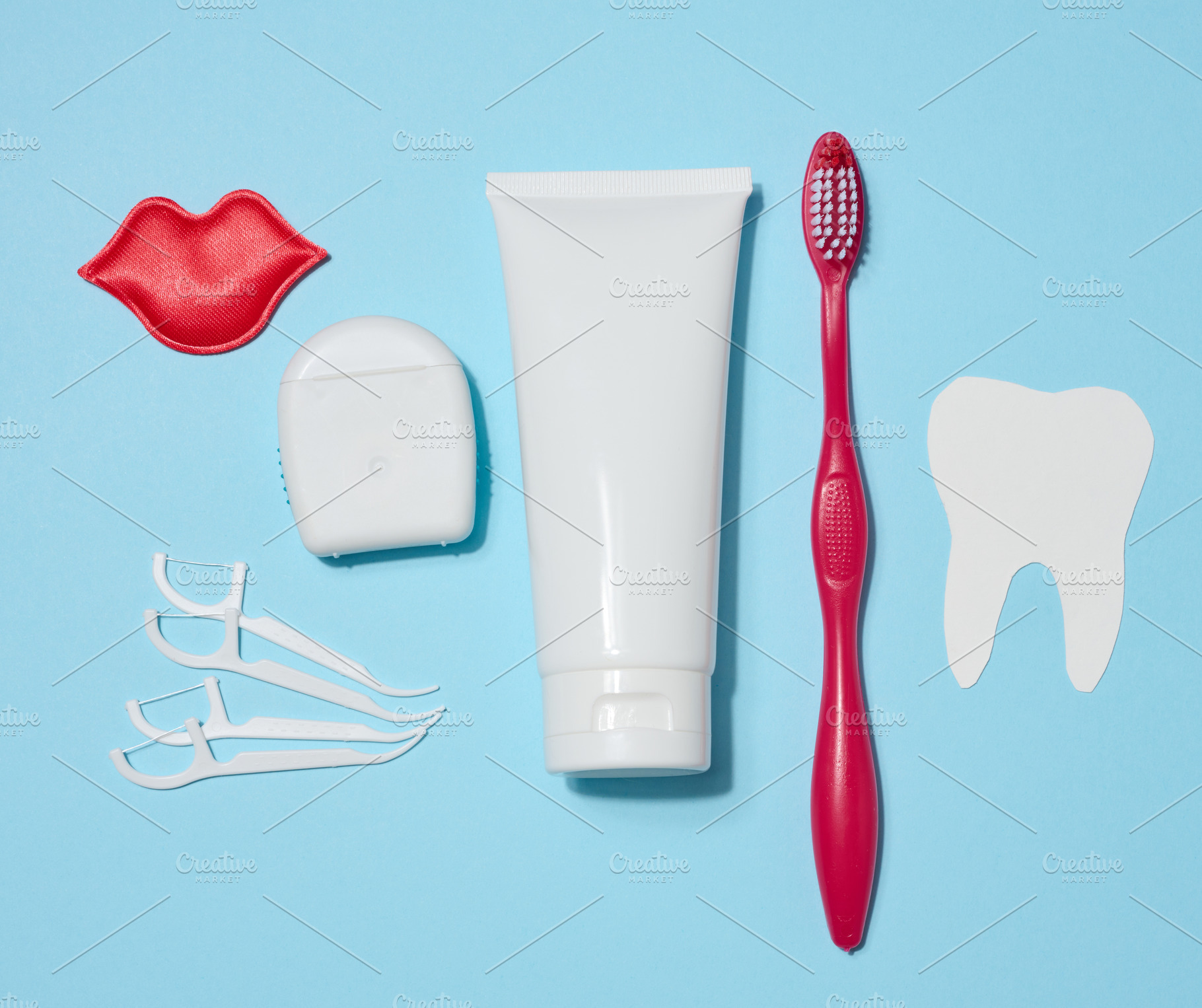 Tube of toothpaste, dental floss, red toothbrush, decorative red, a Health & Medical Photo by ndanko