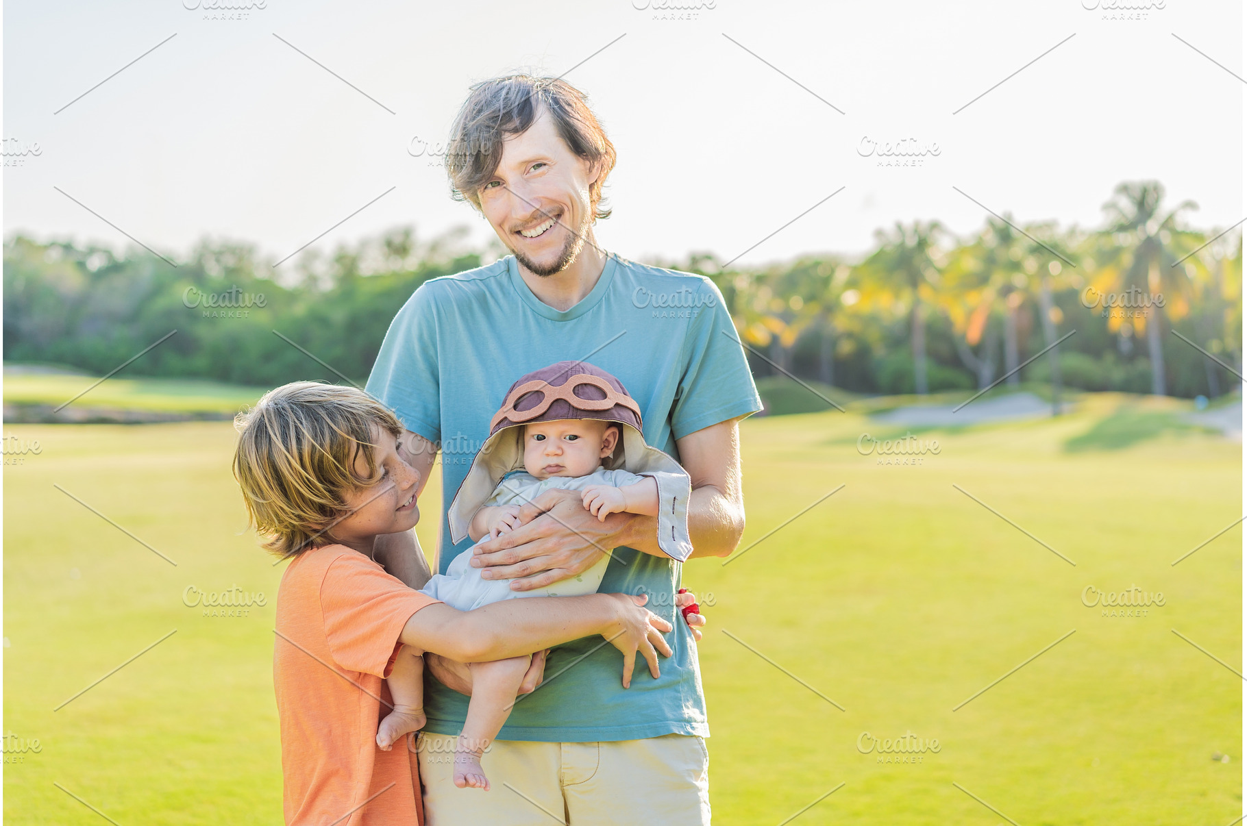 Father, son, and newborn on a meadow, a Holiday Photo by Elizaveta Galitskaya