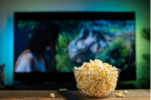 A glass bowl of popcorn and remote, a Technology Photo by Budarinphoto