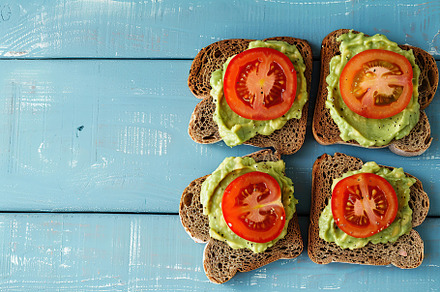 Toast bread with avocado puree and tomatoes on wooden table. Vegetarian food., a Food & Drink Photo by AlyaAnd
