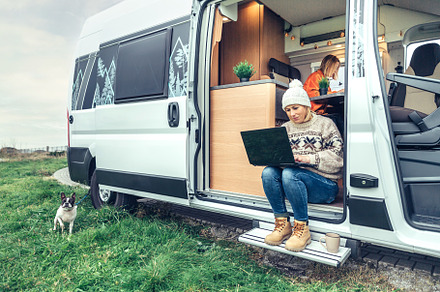 Woman teleworking sitting in the door of a camper van, a Person Photo by davidpereiras