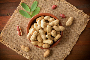 Handful of peanuts in container on sackcloth mat on wooden, a Food & Drink Photo by Davizro's Market