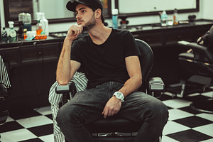 Man is sitting in a barber's chair barber shop containing barber, chair, and