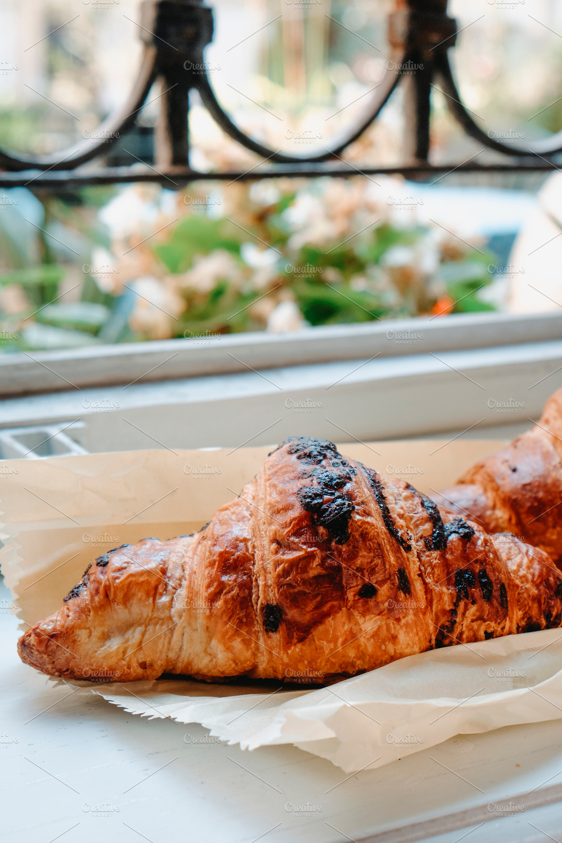 closeup of a chocolate croissant by a window, a Photo by Nito