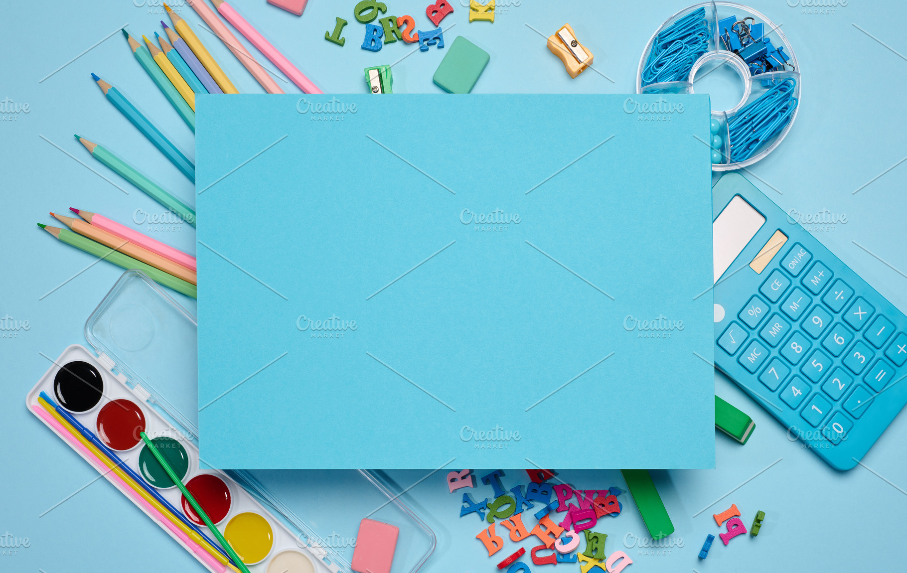 Bue sheet of paper in the center, surrounded by school supplies, a School & Education Photo by ndanko