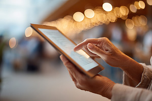 E-reader device mock-up being used outdoors in a cozy, illuminated setting, a Photo by AlyaAnd