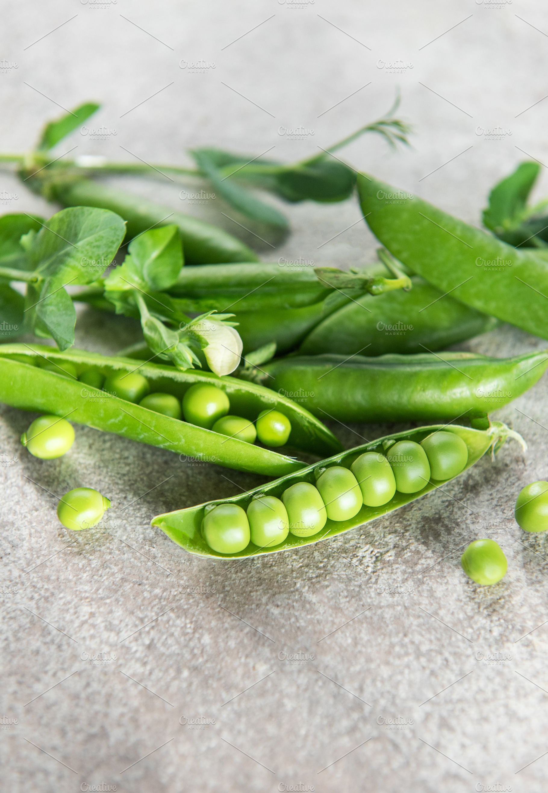 Fresh green peas in pods on stone surface, a Food & Drink Photo by Olena Rudo