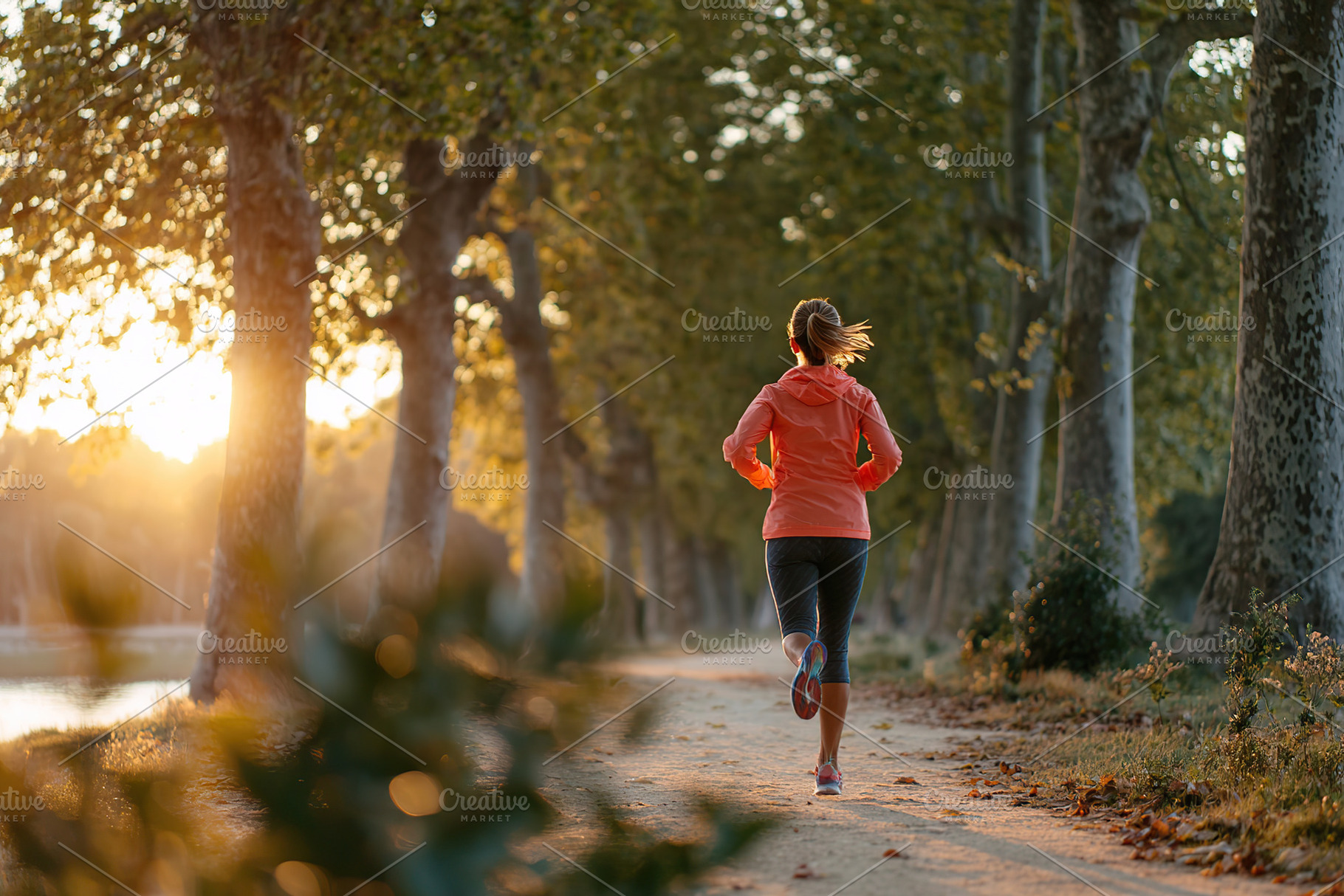 Morning run along a serene path with trees during sunrise in a peaceful park, a Photo by AlyaAnd