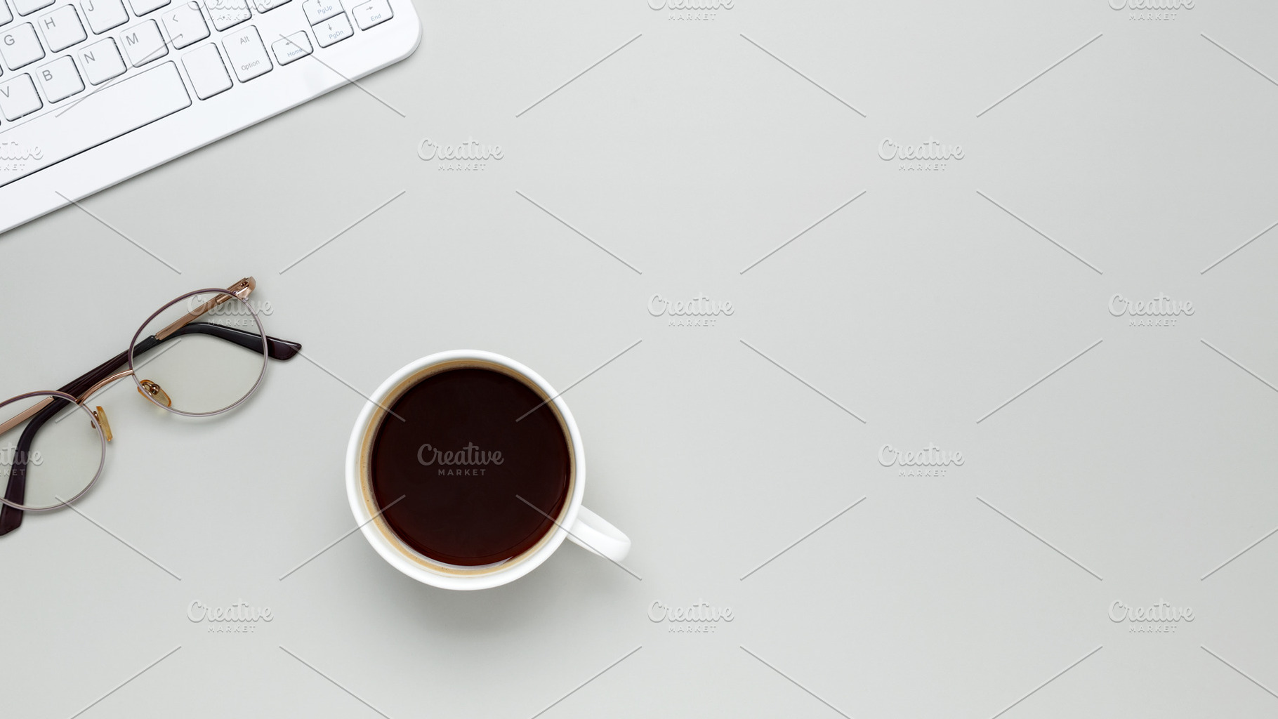 Comfortable workspace setup with coffee cup, keyboard, glasses supporting produ, a Photo by matucha