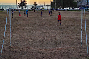 Kids playing soccer at sunset on dry field, a Sports & Recreation Photo by DanFLCreativo