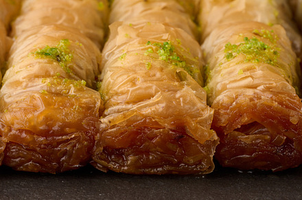 Pieces of baked baklava in honey and sprinkled with pistachios o, a Food & Drink Photo by ndanko