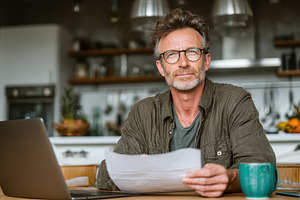 Man reviewing documents at home offi, a Photo by Pixeness Studio