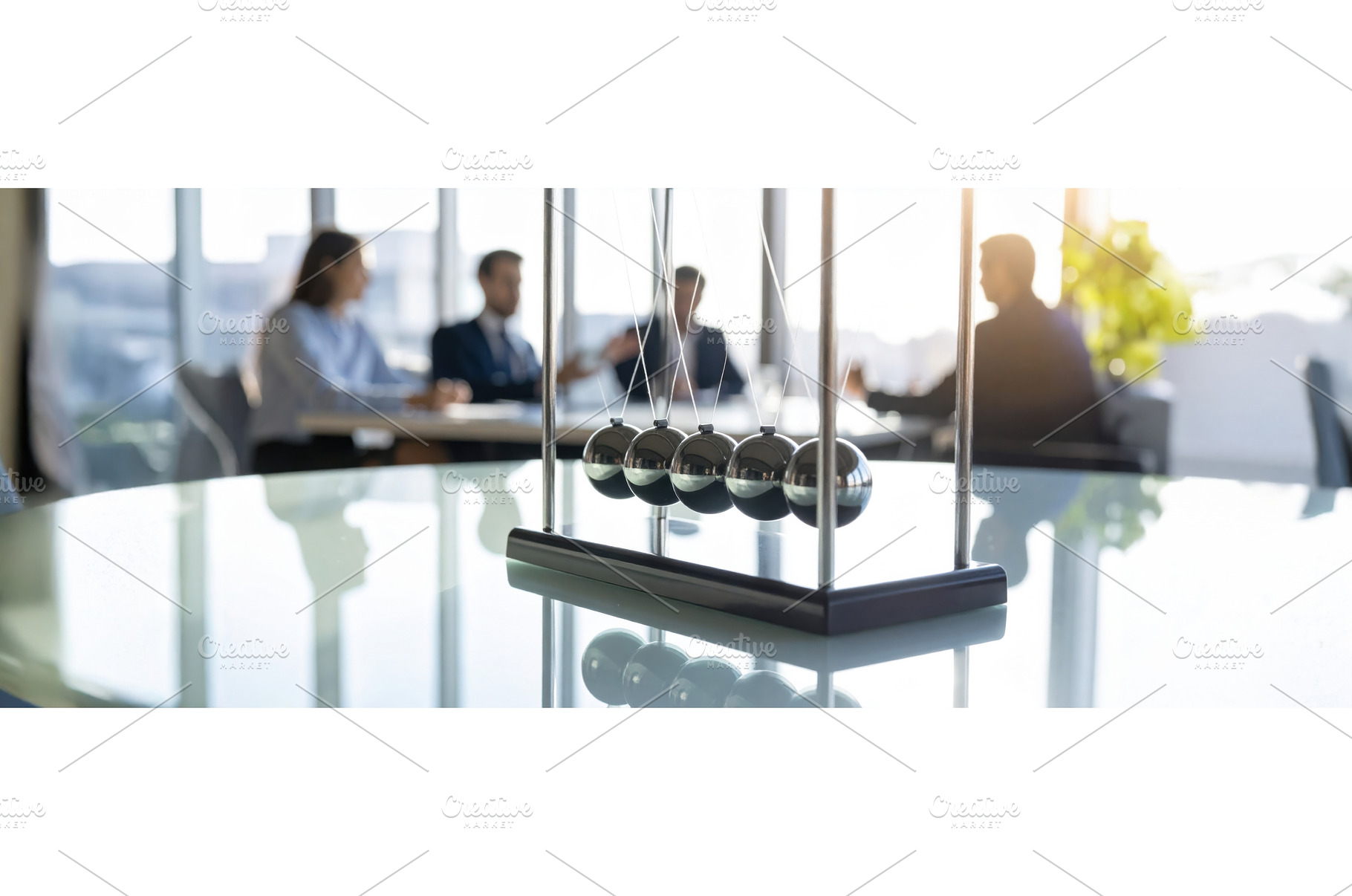 A Newton’s cradle in focus with, a Business Photo by Igor Tichonow