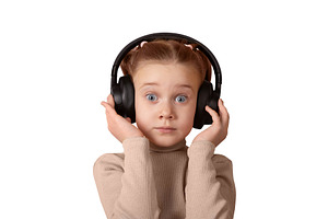 Young girl with headphones, looking surprised. Isolated on white, a Person Photo by Ales Munt