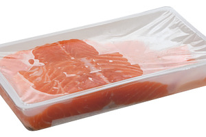 Slices of raw salmon fillets are packaged in a clear plastic tra, a Food & Drink Photo by ndanko